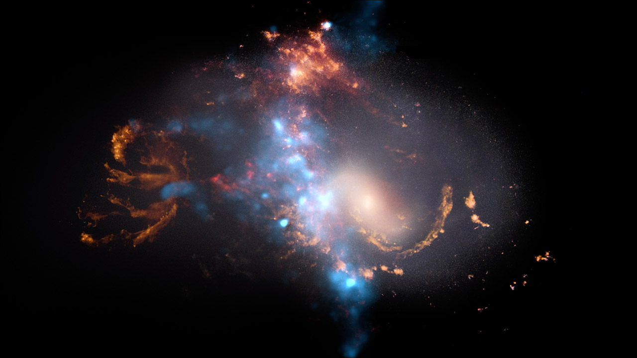 A peculiar galaxy in the center takes up most of the frame against a black background. This asymmetrical object has distorted spiral arms that extend to the left, above, and to the lower right. The galaxy’s arms are light orange and are not smooth or solid in texture, instead resembling blots and streaks of paint. The galaxy’s distorted spiral arms are overlaid by a light blue ridge of blurry blotches, which are brightest and heaviest in the center and fainter toward the left, ending before the orange areas. The blue blotches also extend to the bottom at the center and faintly toward the top center, but are not seen toward the right. A bright, almost-white orange point is near the center right and has a hazy halo surrounding it, taking up about a tenth of the image. Over the majority of the image is a semi-transparent, elliptical-shaped area that has a white, fuzzy glow.