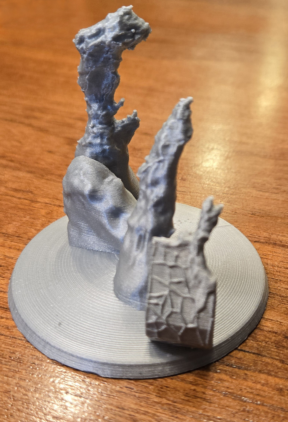 Photo of a 3D print of M16, the Eagle Nebula. The print is about 5 inches tall, built using blue plastic. There are three vertical columns staggered, rising up like fingers extending from the palm of a hand.